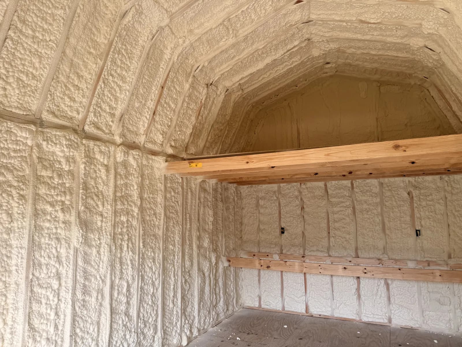 Spray foam insulation on the walls and gambrel roof of a barn building