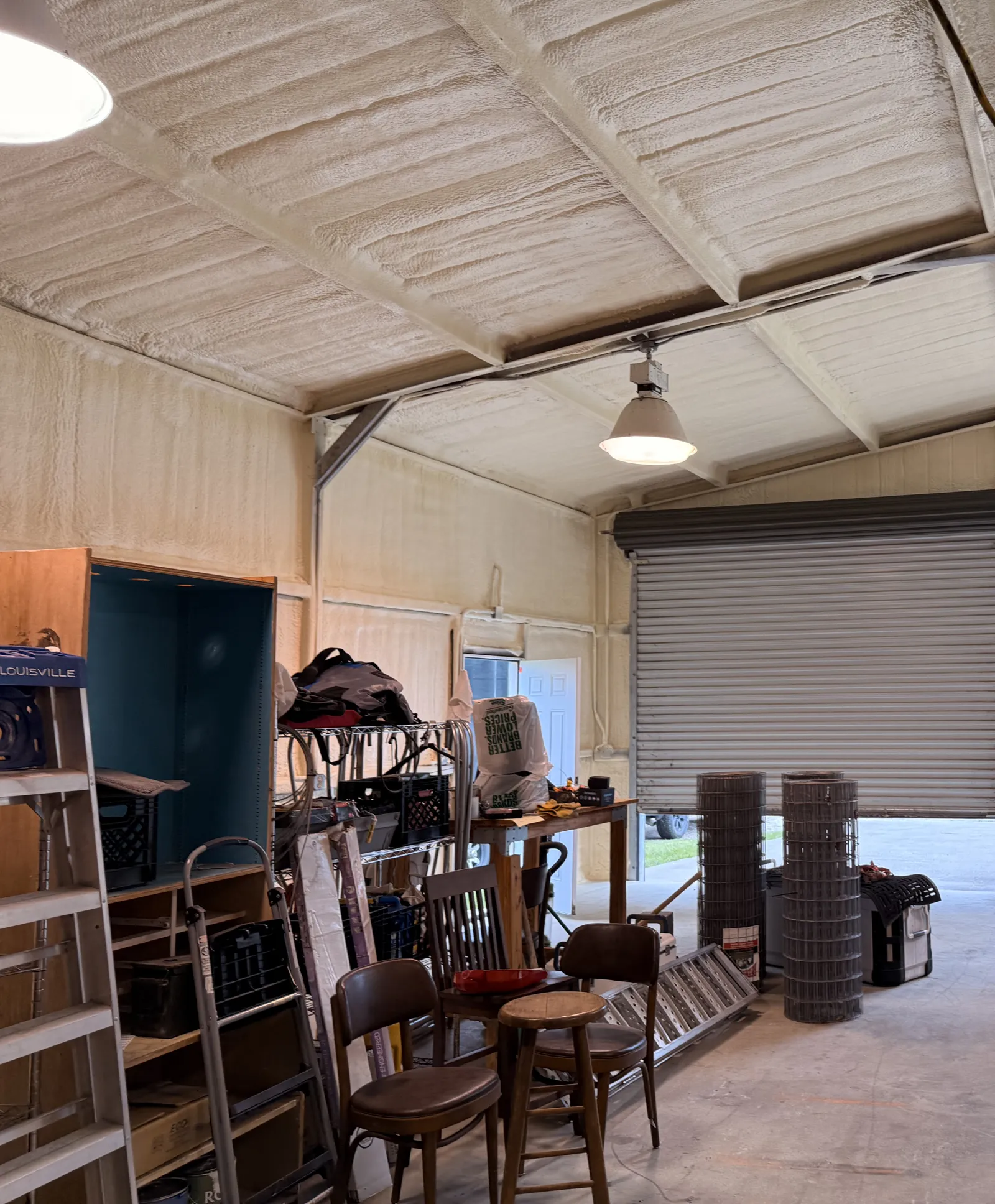 Metal shop with spray foam insulated walls and roof around a roll-up door